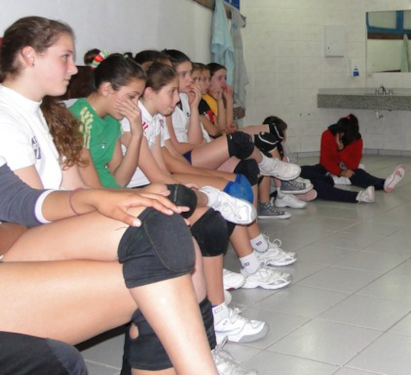 Een volleybal team zit teneergeslagen in de kleedkamer na een slechte wedstrijd.