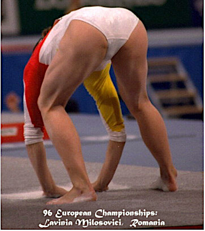 Laviana Milosovici in een rood, wit en geel pakje buigt voorover om de vloer aan te raken tijdens de Europese Kampioenschappen van 1996. Tekst onderaan identificeert Lavinia Milosovici uit Roemenië.